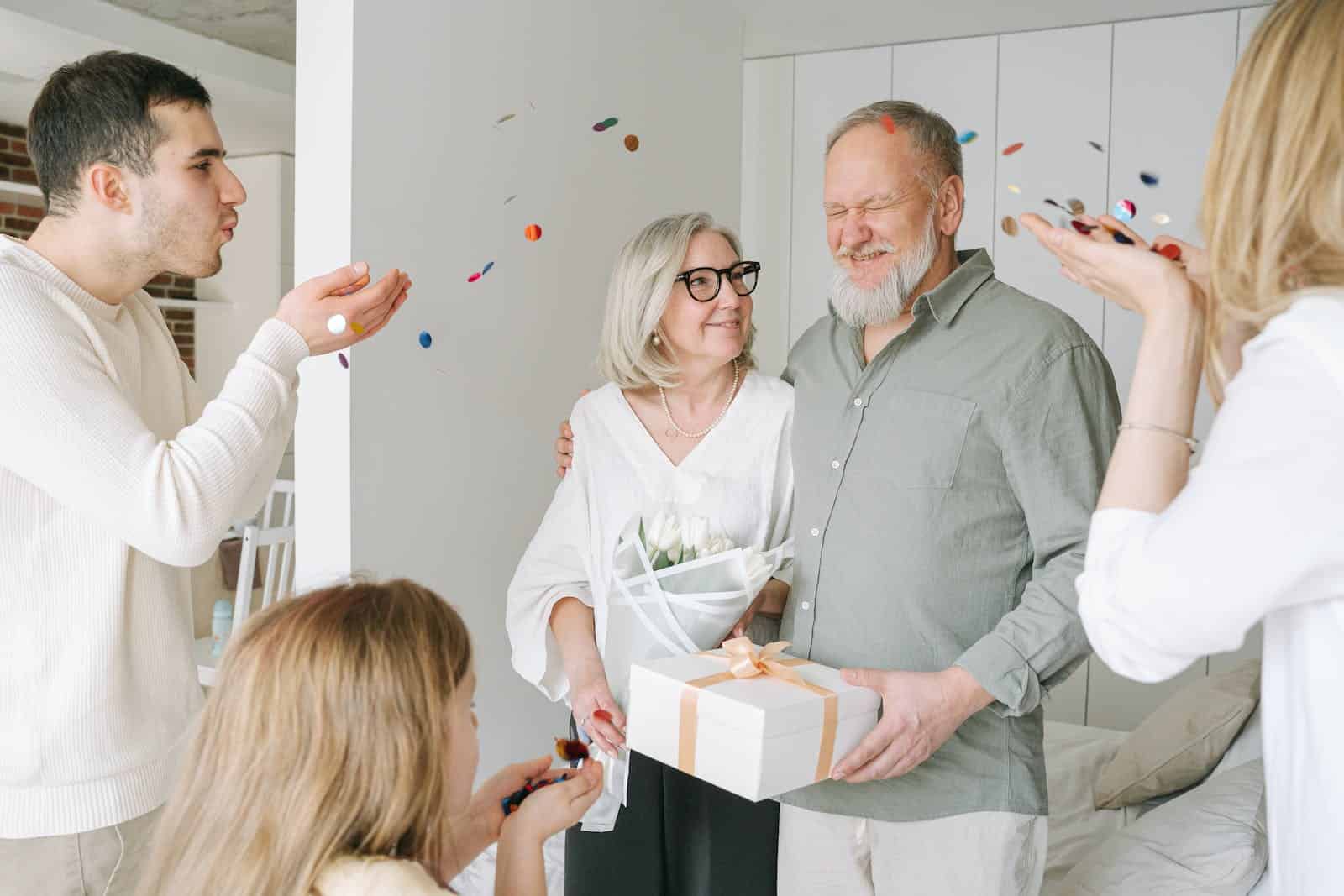 A Man and a Woman Blowing Confetti to an Elderly Couple